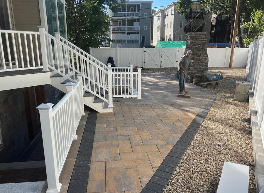 Finished paver patio with a stone border in a South Shore, MA backyard